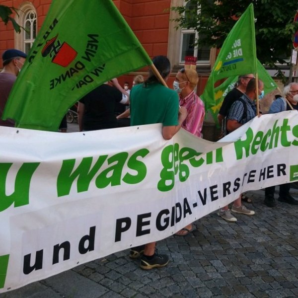 Menschen mit Banner (Aufschrift Tu was gegen rechts und Pegida-Versteher und Fahnen "Nazis nein Danke" 