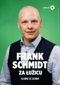Bildbeschreibung:  Plakatmotiv mit Frank Schmidt, Hintergrund grün, oben rechts Sonnenblume und gruene.de, er hat eine dunkle Weste und ein helles Hemd an. Text: FRANK SCHMIDT ZA ŁUŽCU SŁOWO JE SŁOWO  
